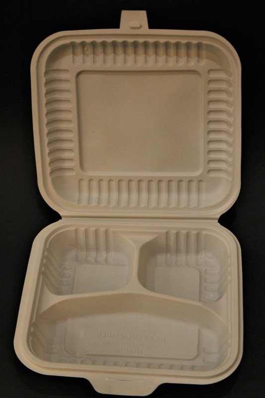 An open bagasse clamshell box with three compartments.